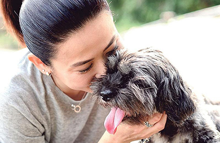 A woman kisses a dog