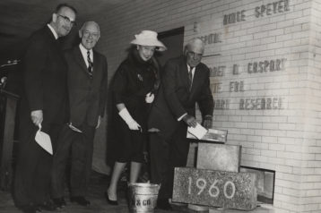 Group of people next to 1960 plaque