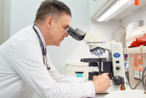 A veterinarian looking into a microscope