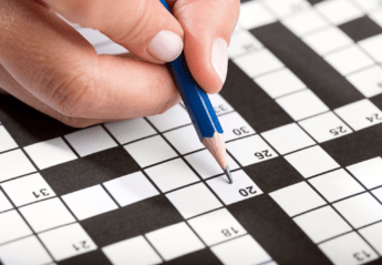 Person solving crossword puzzle