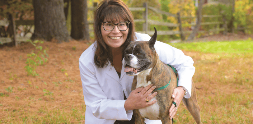 Dr. Renee Alsarraf posing with Dusty, her boxer