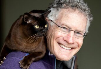Dr. Jonathan Losos with his cat Nelson sitting on his shoulder.