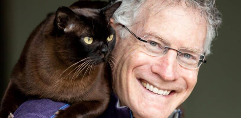 Dr. Jonathan Losos with his cat Nelson sitting on his shoulder.